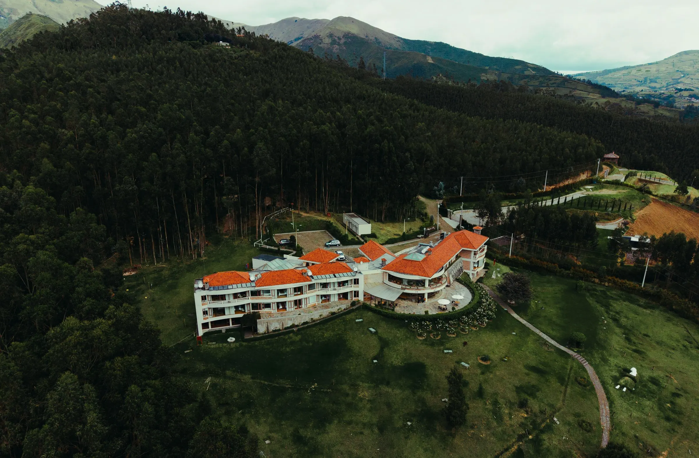 Vista aérea del hotel entre el bosque y las montañas
