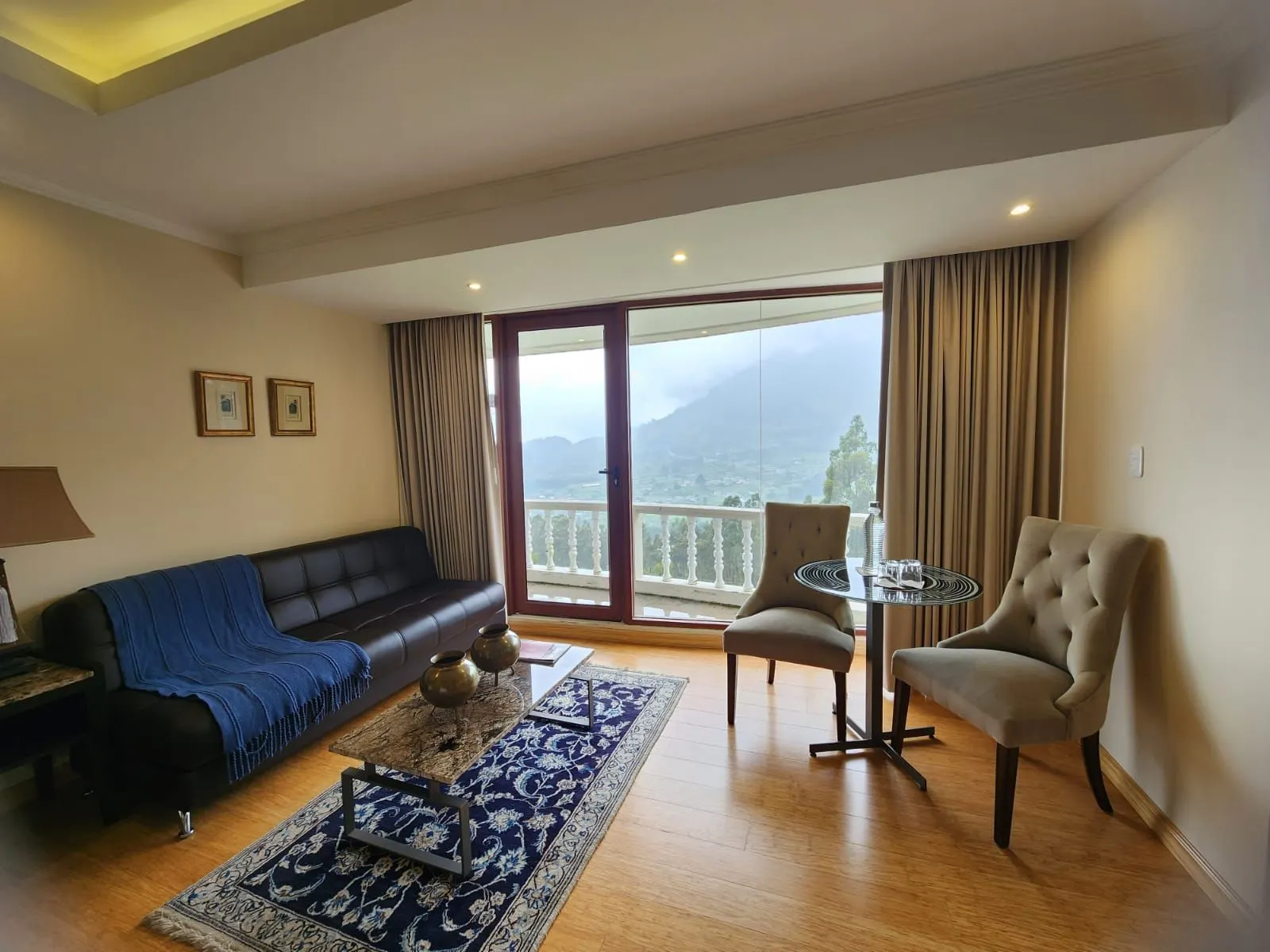 Rincón de estar de la habitación con sofá azul junto al balcón