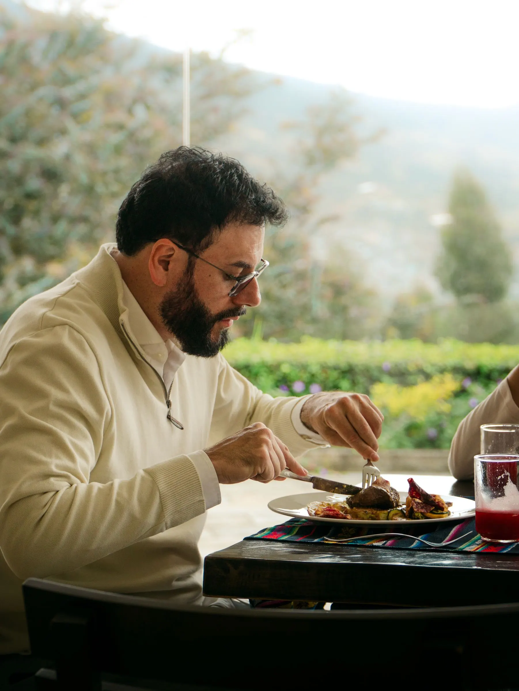 Huésped almorzando en El Mirador con el jardín de fondo