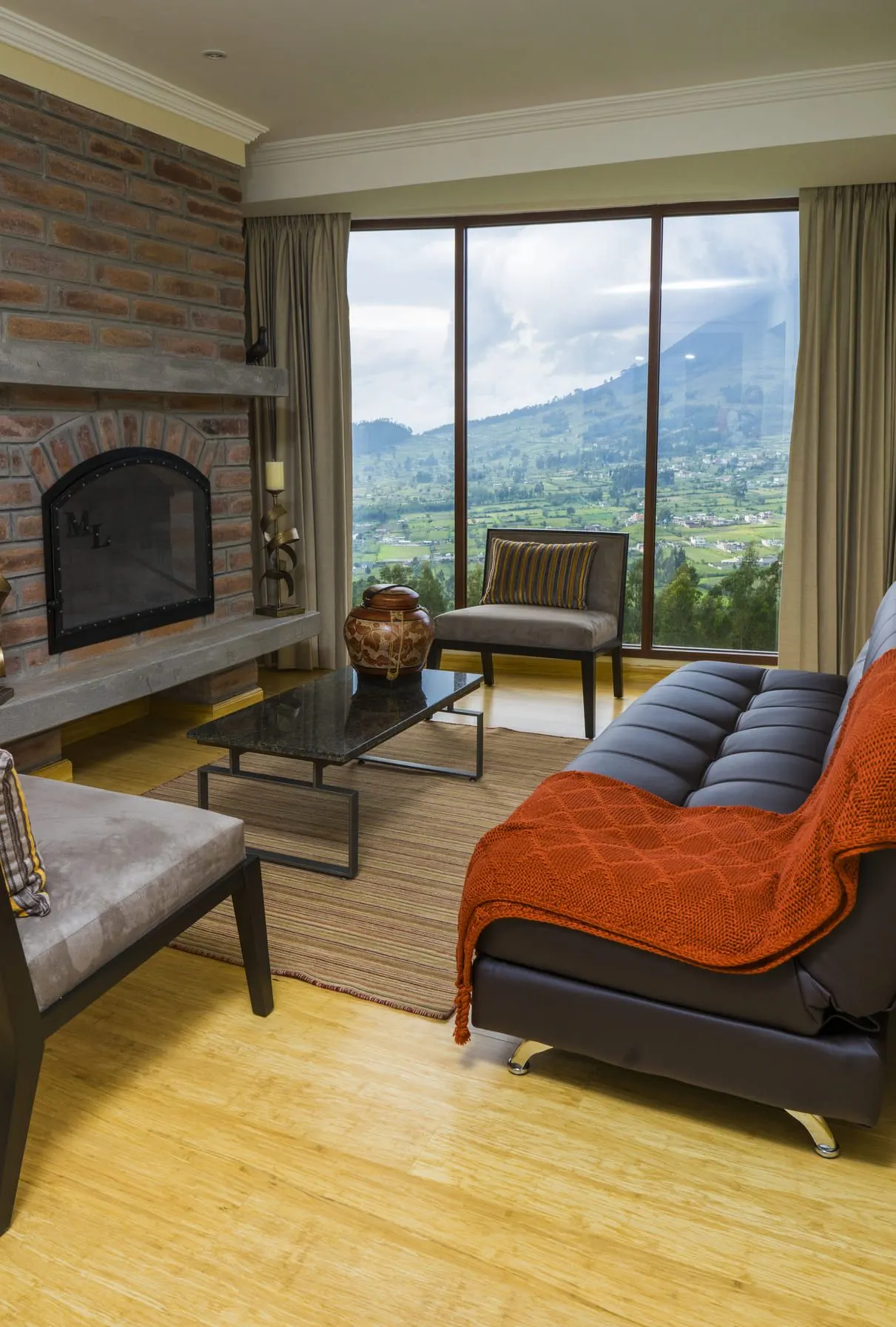 Salon de la Suite avec cheminée en pierre et baie vitrée face à la montagne
