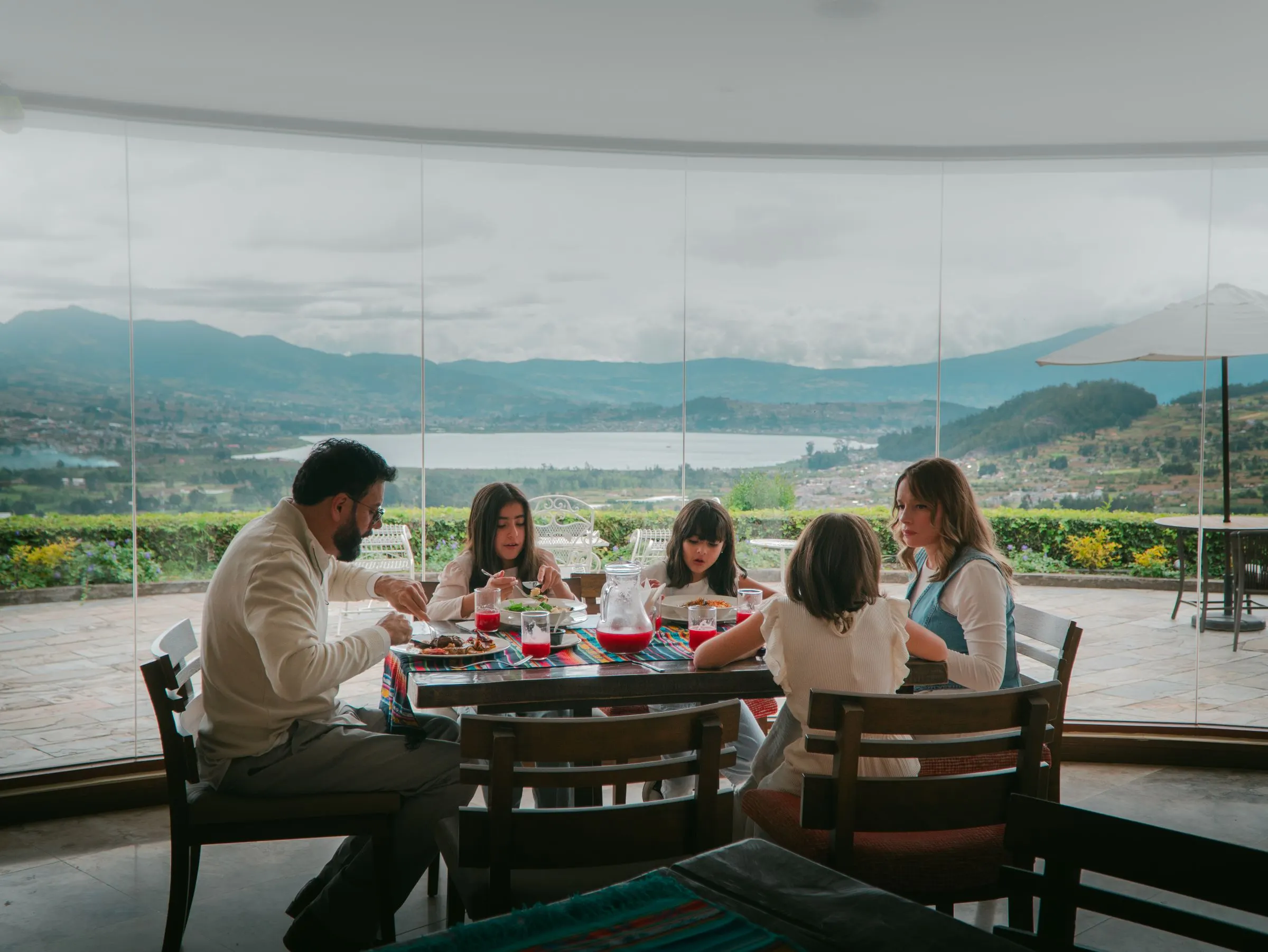 Familia almorzando en la terraza de El Mirador con el lago al fondo