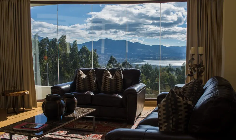 Sala con sofás de cuero y ventanal hacia el lago