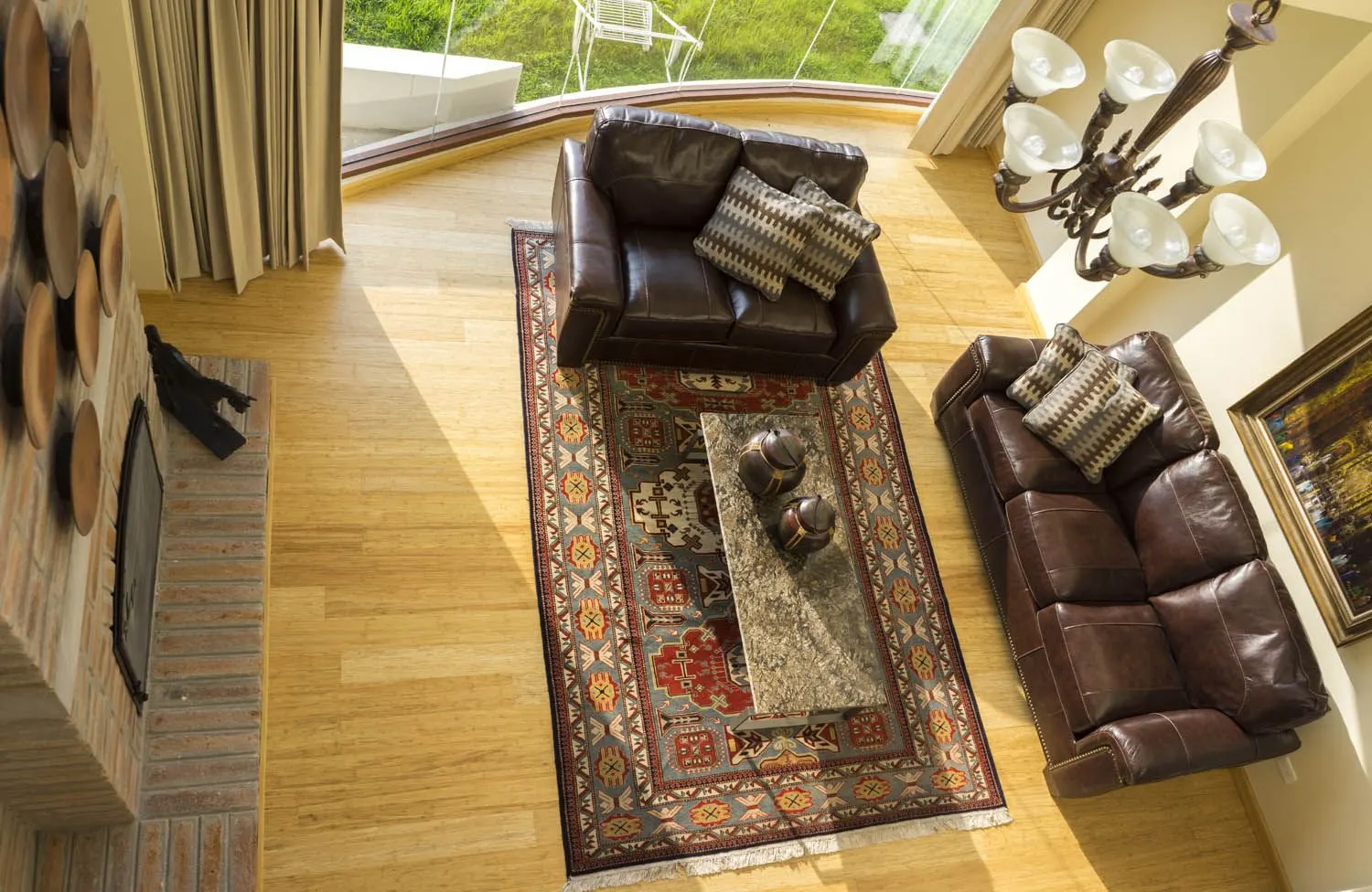 Sala de doble altura con chimenea, sofás de cuero y alfombra tejida vista desde arriba