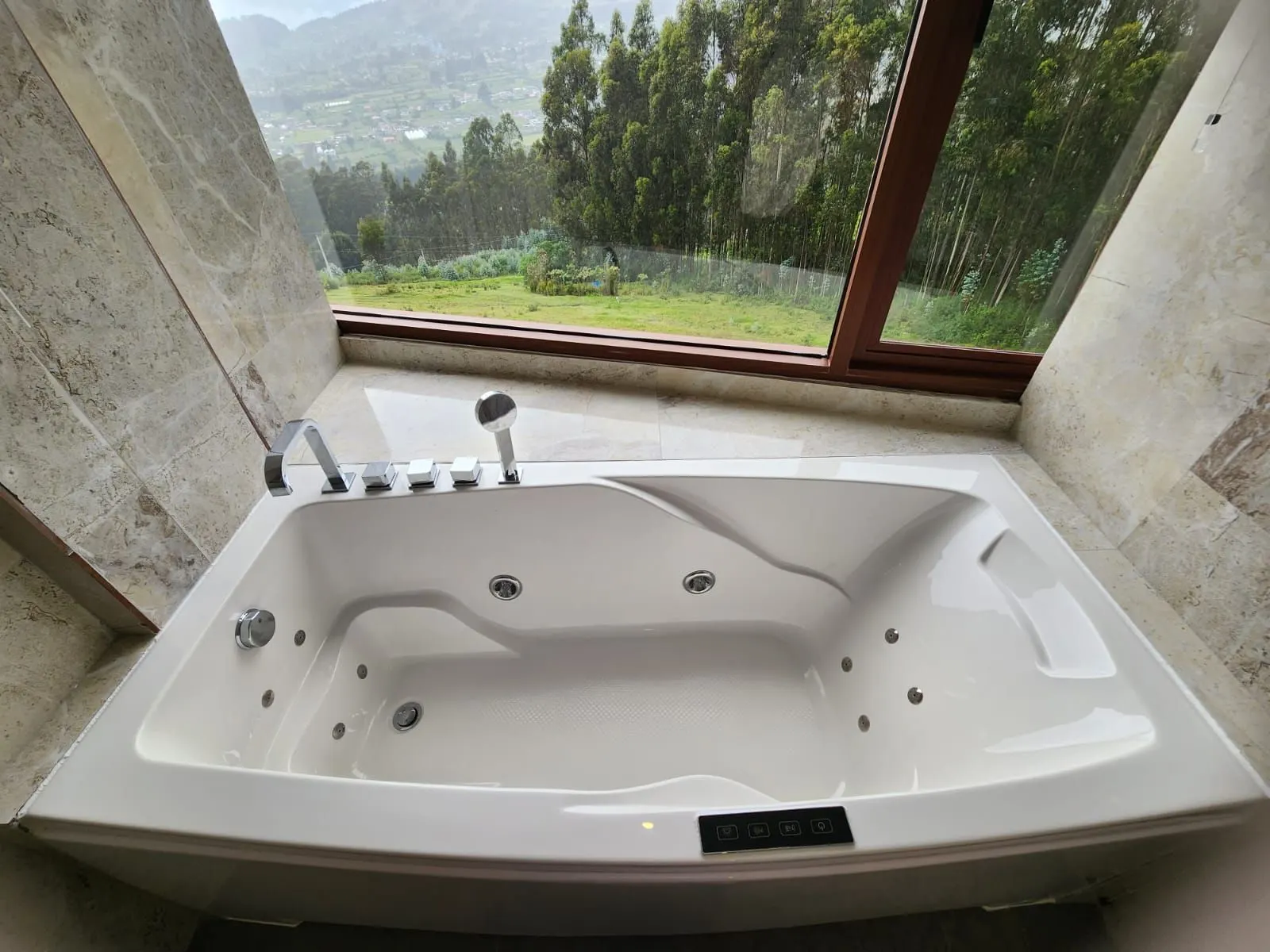 Baignoire en marbre de la Suite près de la fenêtre, avec vue sur la forêt