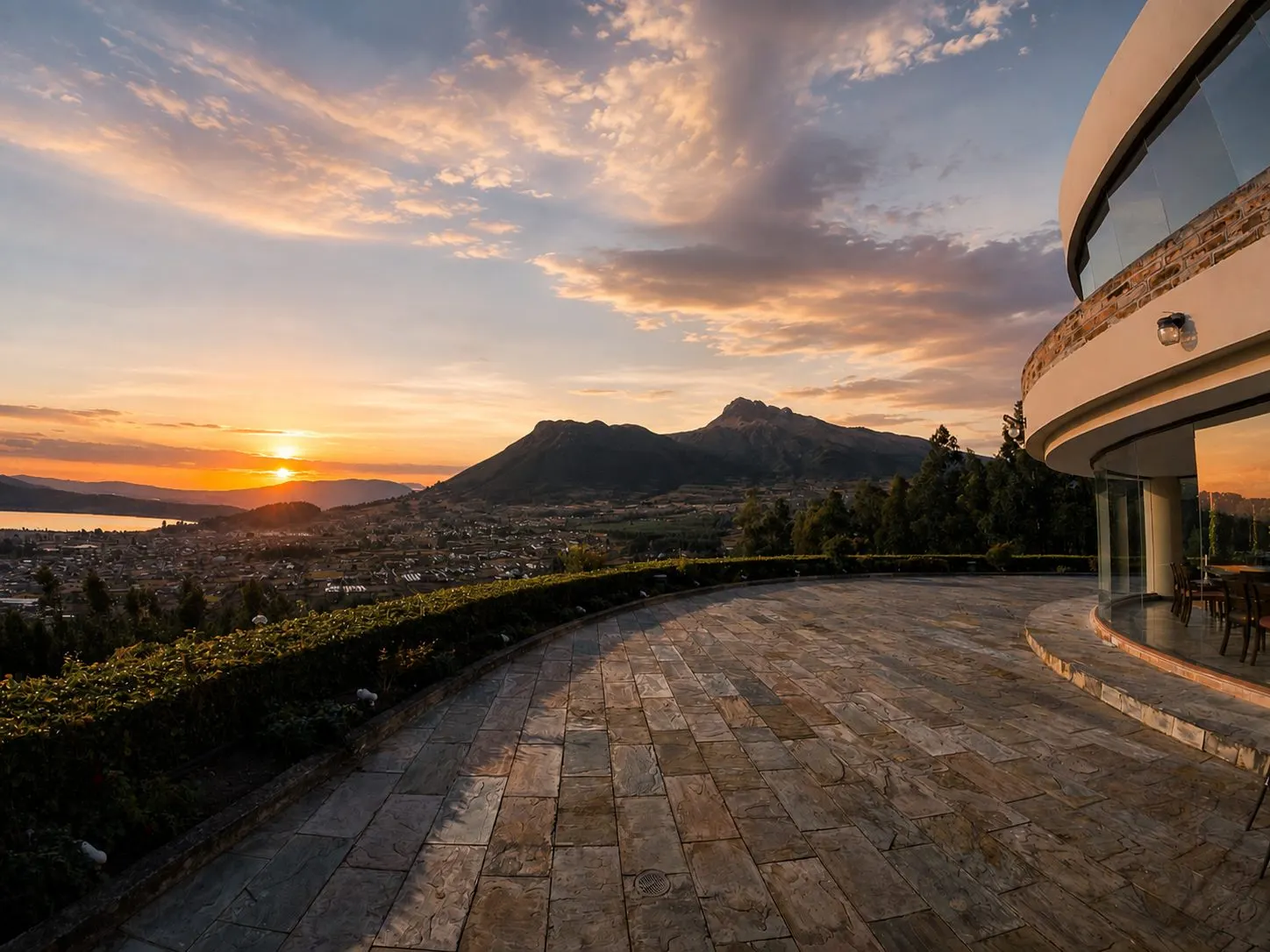 Terrasse von El Mirador bei Sonnenuntergang, mit der Sonne über dem See und den Bergen